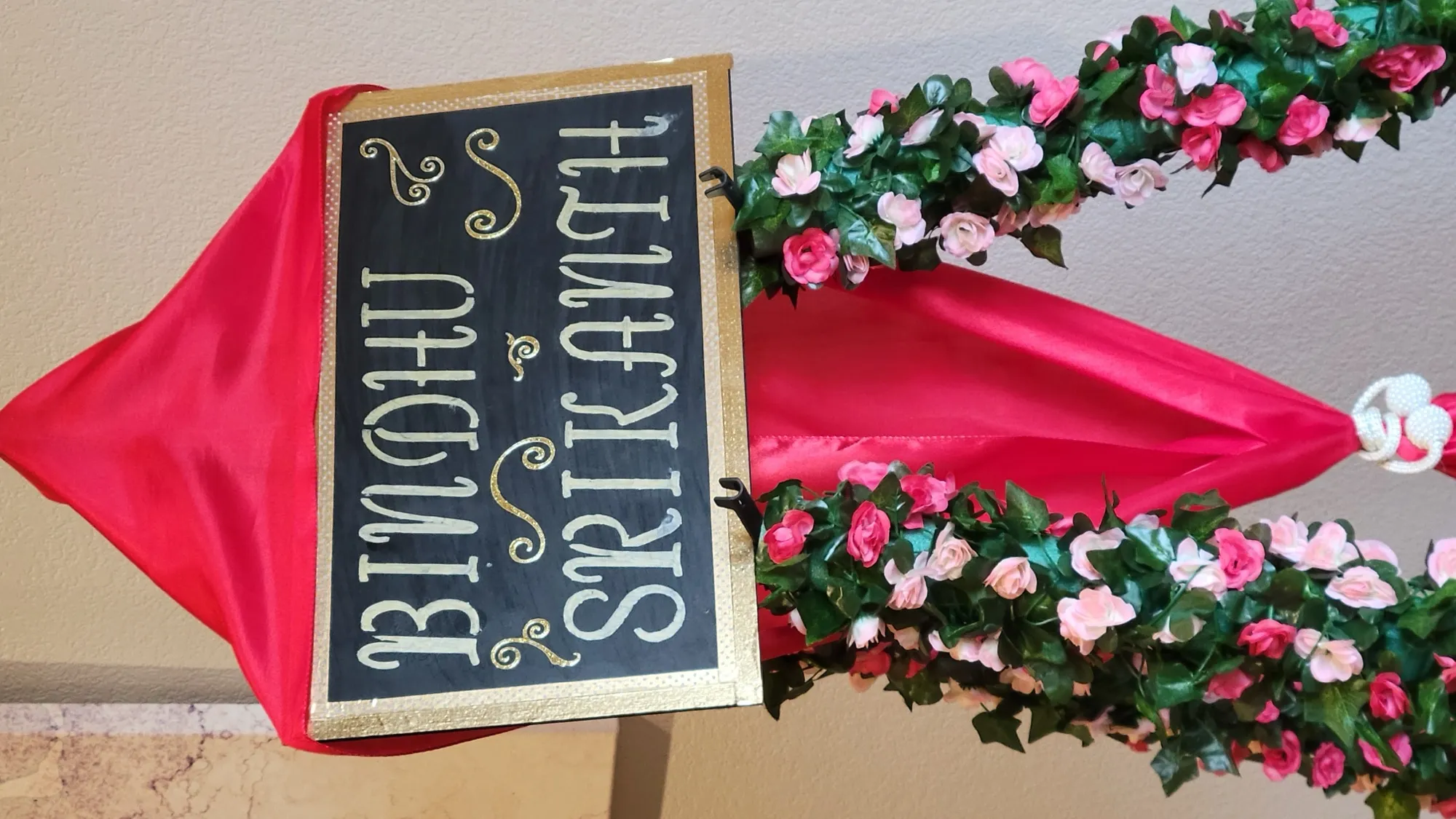 Bindhu srikanth name board wreath — Sequin Drapes & Red Loveseat Reception
