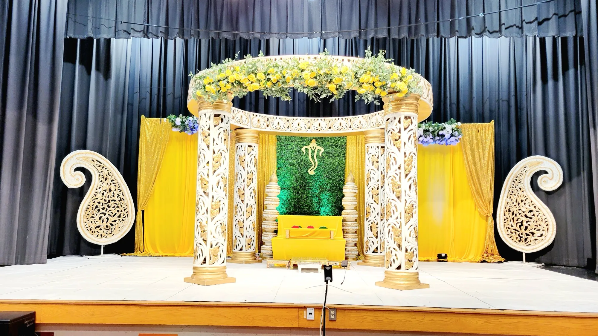 Mandap wide shot stage lighting — Yellow & Gold Mandap with Paisley Pillars