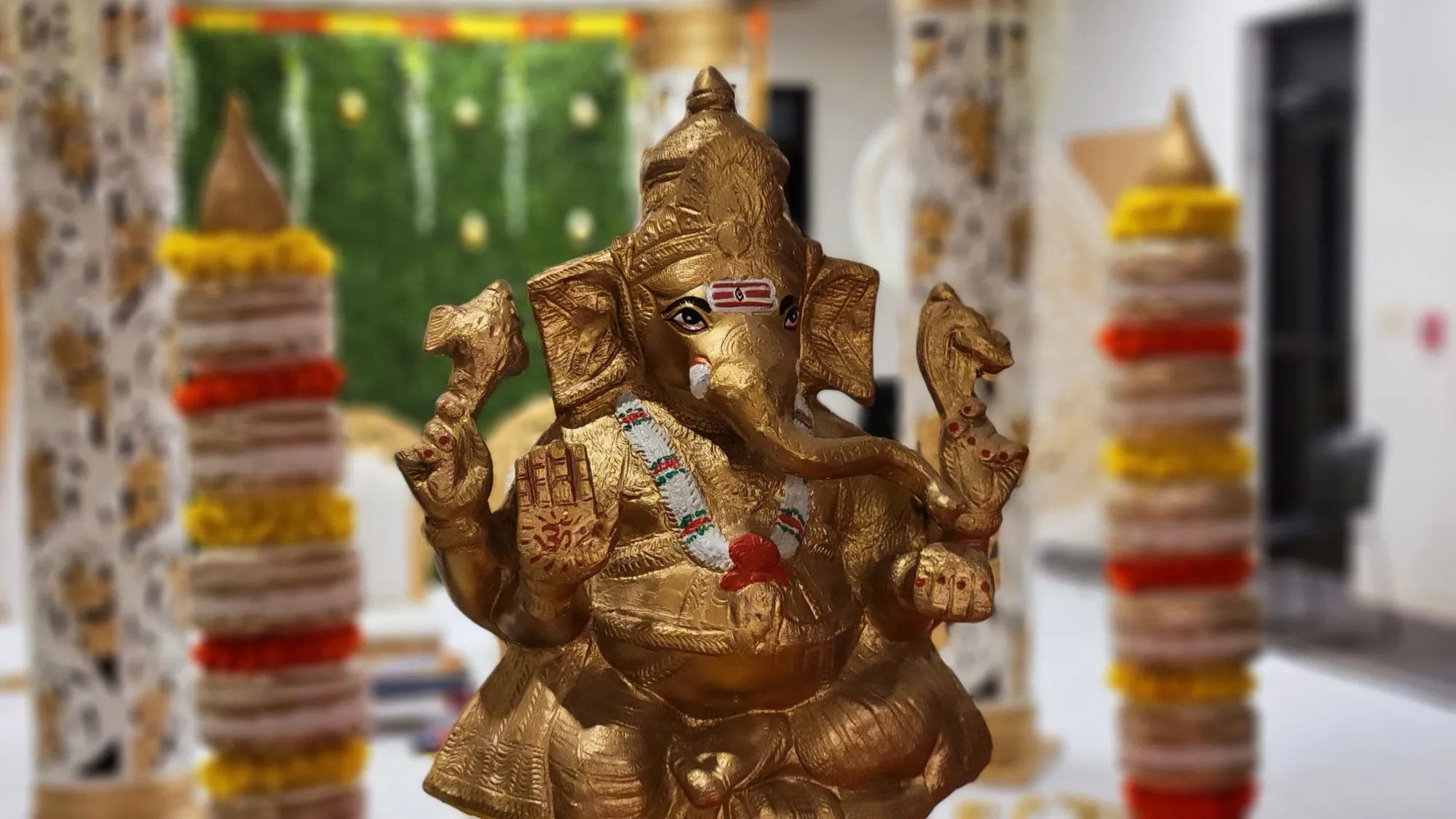Ganesha statue closeup marigolds — Traditional Gold & Marigold Mandap