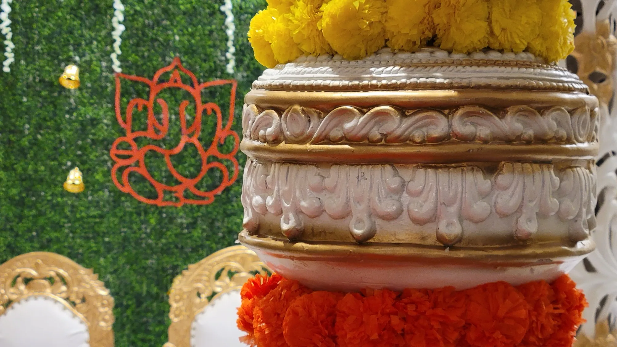 Pillar cap greenery backdrop detail — Traditional Gold & Marigold Mandap
